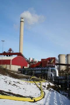 Industrial pipelines and smoke stack against blue sky Stock Photos
