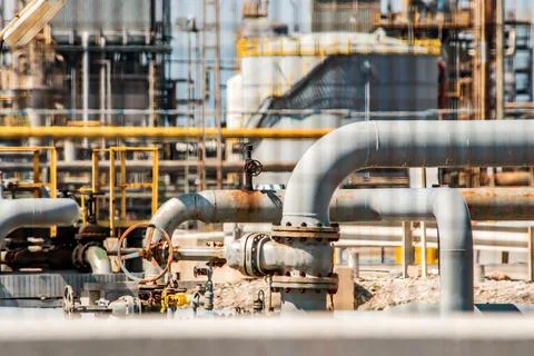 Industrial pipes and valve system inside refinery with metal structures, pr.. Stock Photos