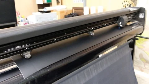 Industrial plotter cuts black adhesive film Stock Footage 117223217