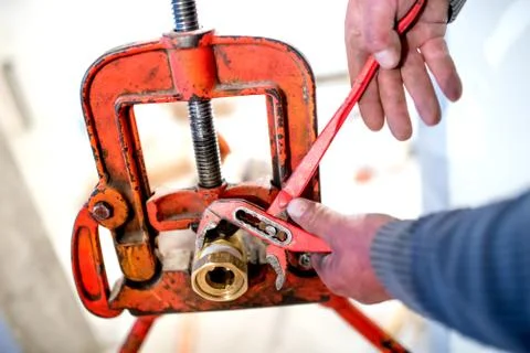 Industrial plumber using adjustable wrench for copper pipes instalation Stock Photos