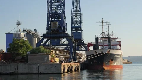 Industrial port crane loading cargo ship at dock Stock Footage 345004691