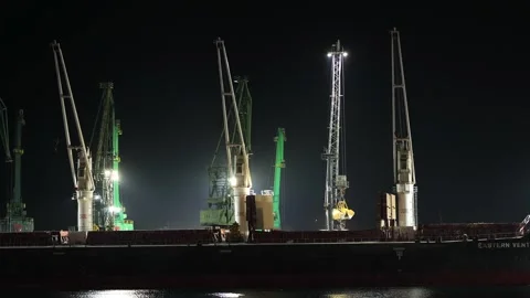 Industrial port cranes loading cargo ship at night Stock Footage 341376810