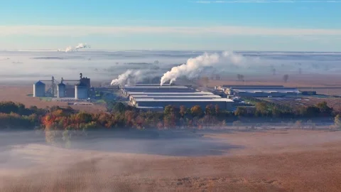 Industrial poultry farm processing facility with grain silos emitting steam Stock Footage 327648782