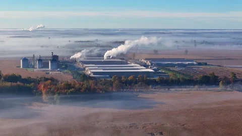 Industrial poultry ranch operation with processing plants and silos in mist Stock Footage 328814446