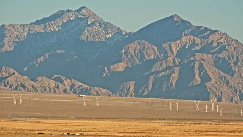 Industrial power lines cutting through barren desert 스톡 동영상 326239648
