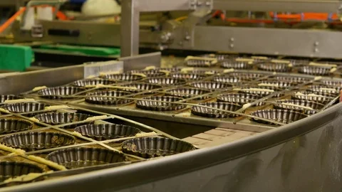 Industrial process of Empty pastry molds on a conveyor belt in a bakery factory Stock Footage 81711366