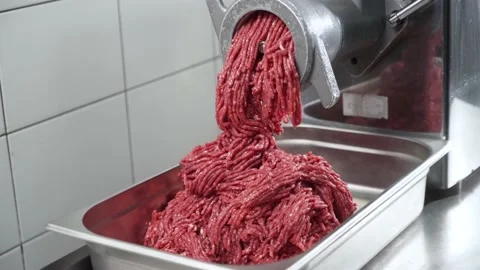 Industrial processing lard or beef meat in minced meat on a meat grinder at a Stock Footage 239013422