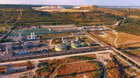 Industrial processing plant with pipelines below terraced quarry. High angle Stock Footage 339368196
