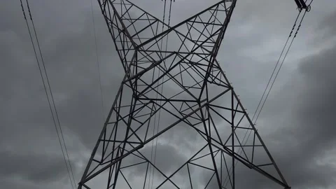 An industrial pylon cuts through dense, overcast clouds, capturing the grit of a Vídeos de archivo 337476807
