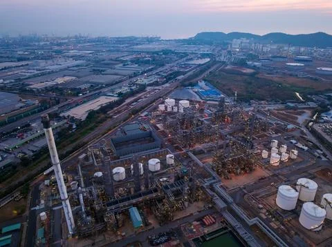 Industrial Refinery Complex Illuminated At Twilight Near Coastal Logistics .. 库存照片