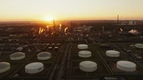 Industrial refinery complex with smoke and tanks at sunset Stock Footage 319016127