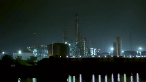 Industrial refinery at night with illuminated structures reflecting on calm.. Stock Footage 340221449