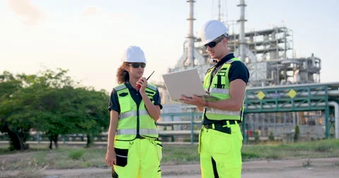 Industrial refinery supervisor checking maintenance document on laptop while Stock Footage 335603547