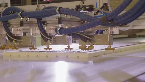 Industrial robot arms assembling boxspring beds in a factory setting, with Stock Footage 270105764