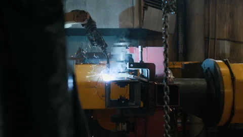 Industrial Robot Performing Automated Welding in Metal Fabrication Shop Stock Footage 320680544