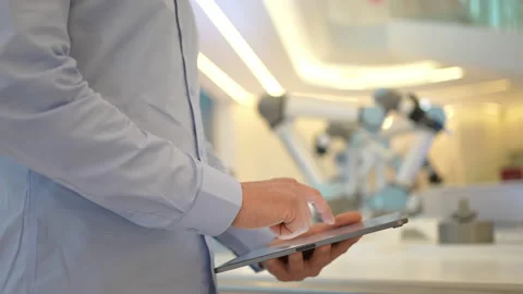 Industrial robotics engineer man using tablet, futuristic robot arm. Factory Stock Footage 170476906