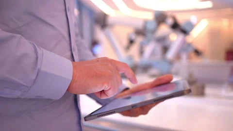 Industrial robotics engineer man using tablet, futuristic robot arm. Factory Stock Footage 170477053