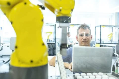 Industrial Robots Development An engineer developing the industrial robot.... Stock Photos