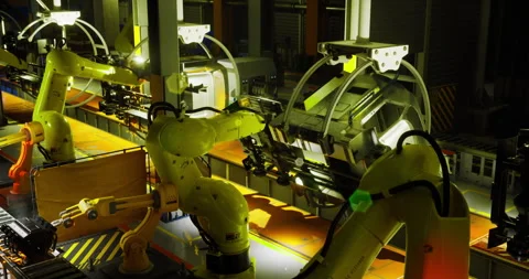 Industrial robots at night working on assembly line in a manufacturing facility Stock Footage 325025486