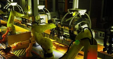 Industrial robots at night working on assembly line in a manufacturing facili Stock Illustration