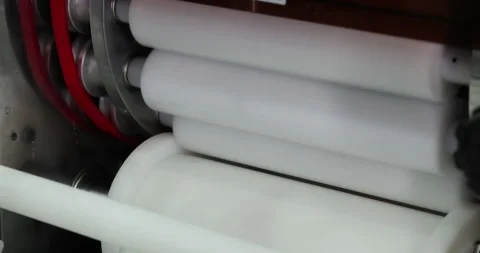 Industrial rollers processing material in automated food production machine Stock-Footage 346704780