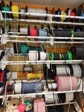 Industrial ropes cables and chains stacked in organized coils and reels on .. 写真素材