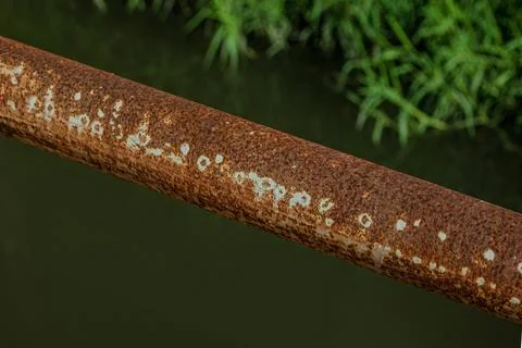 Industrial rust texture on iron pipe over canal water near midnight Фото