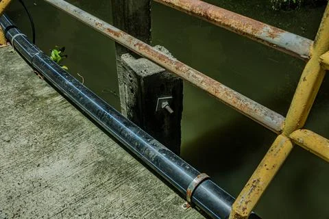 Industrial rust texture on iron railing along streetlight concrete base a Stock Photos