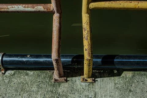 Industrial rust texture on iron railing infrastructure over canal at nigh Stock Photos