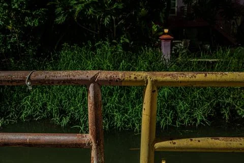 Industrial rust texture on iron railing infrastructure over canal at nigh Stock Photos