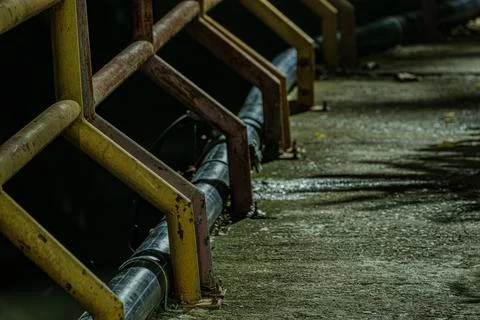 Industrial rust texture on iron railing with shadows on concrete walkway  Photos