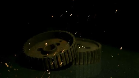 Industrial rusty gears falling with orange sparks in slow-motion Stock Footage 327580206