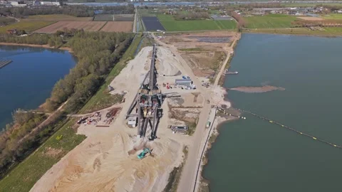 Industrial sand quarry with conveyor belts beside a floating solarfarm on a lake 库存影片 332613402