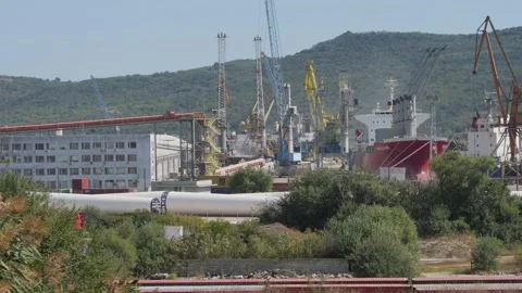 Industrial seaport cranes loading cargo onto bulk carrier ship Stock Footage 345928311