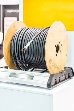 Industrial setting showcasing a dark cable reel on a display stand, against.. 写真素材