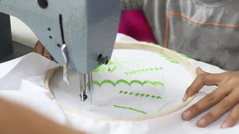 Industrial Sewing Machine Creating Green Embroidery on White Fabric Vídeos de archivo 333563279