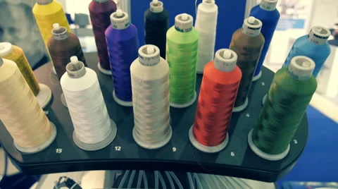 Industrial sewing machine embroiders on program, pattern of white thread on blue Stock Footage 68368982