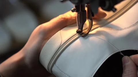 Industrial sewing machine stitching a decorative seam along a pale grey leather Stock Footage 346303218