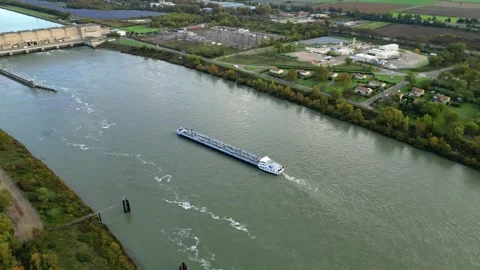 Industrial ship passing through the power plant on the Rhone river Stock Footage 289842956