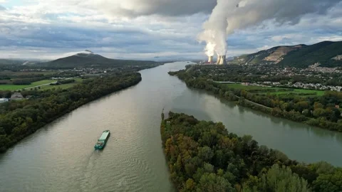 An industrial ship sails down the Rhone River in the morning with steam rising Stock Footage 289841224