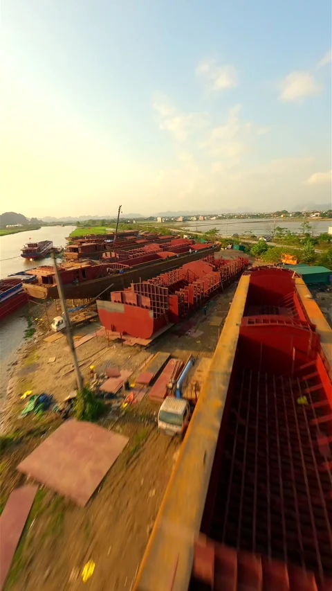 Industrial shipyard constructing large barges along the river canal in Vietnam Stock Footage 274805117