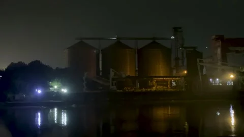 Industrial silos at night with reflections on a calm river under a dimly li.. Stock Footage 340221471