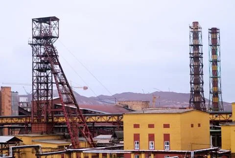 Industrial site features towering structures and machinery amidst a backdrop Stock Photos