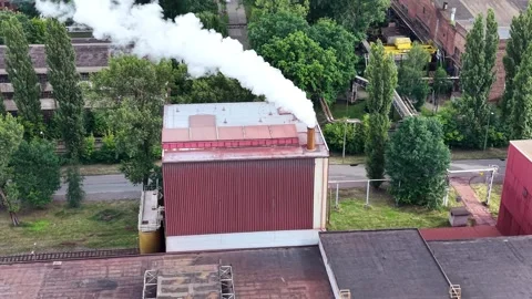 Industrial smoke stack emits white smoke from a factory building Stock Footage 339566863
