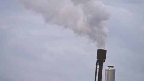 Industrial smoke stack emitting heavy gray emissions into cloudy sky atmosp.. 動画素材 339449459