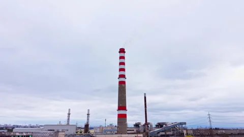 Industrial smoke stack towers in a city area with a cloudy sky during the day Stock Footage 331952813