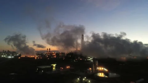 Industrial smoke stacks sunset - Camera drops down to reveal power line Video stock 141430872