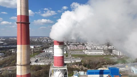 Industrial smokestacks release thick clouds of smoke into the blue sky Video stock 332133387