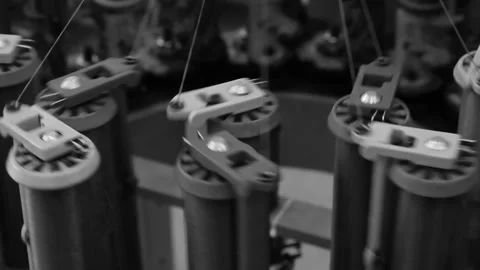 Industrial spools hold wire, each with tension mechanisms. Threads unwind smo Stock Footage 337629567