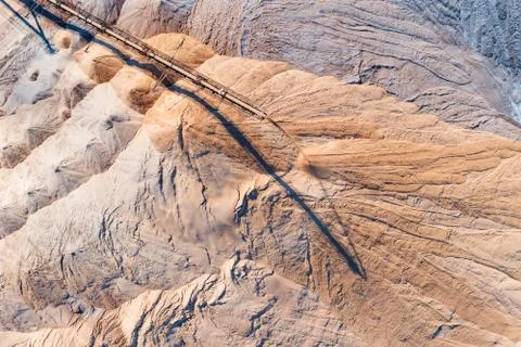 An industrial spreader in the process of work. The process of pouring rock piles Stock Photos